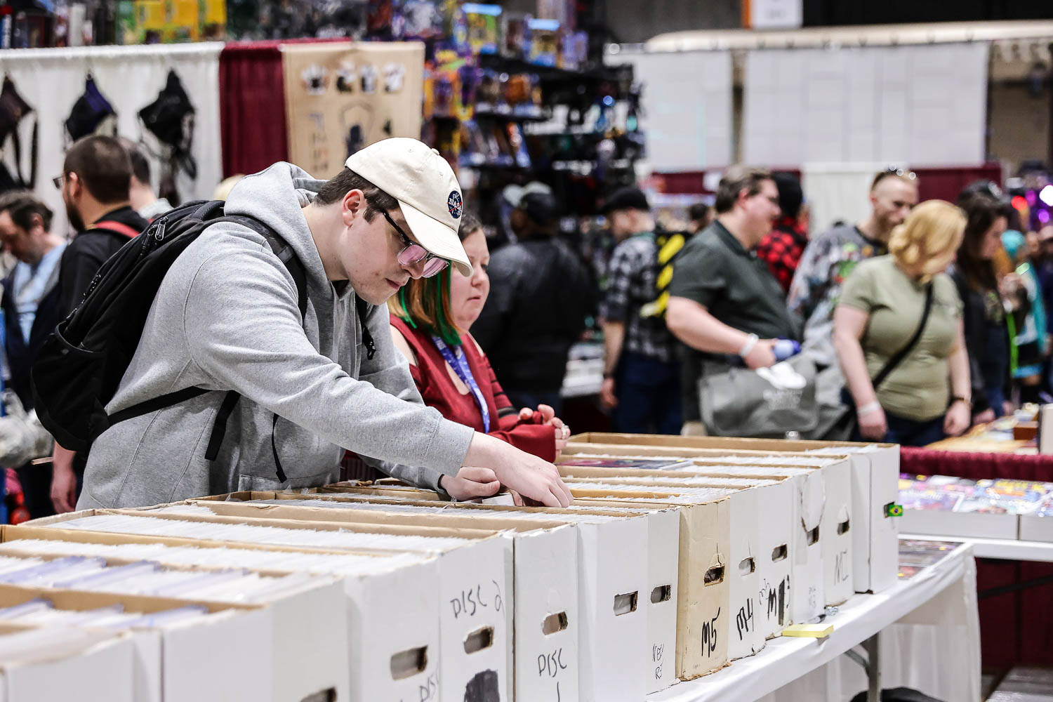 Guests looking through boxes of comics on Saturday at the 2023 Planet Comicon in Kansas City, Missouri on March 18, 2023.